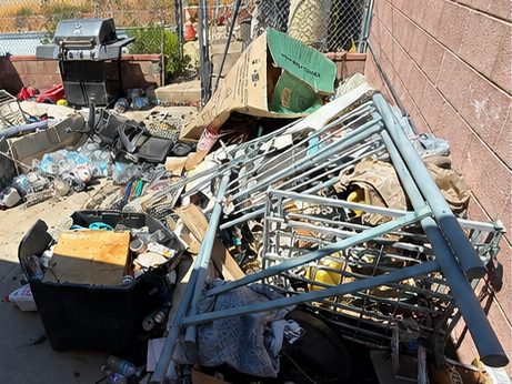 Metal shelving, boxes and bins piled up in a backyard